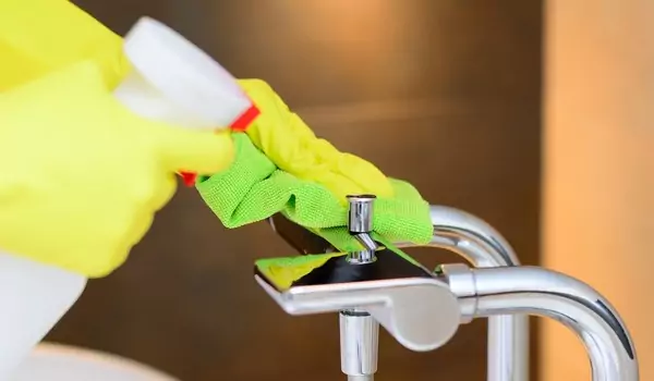 cropped picture of a person cleaning a tap