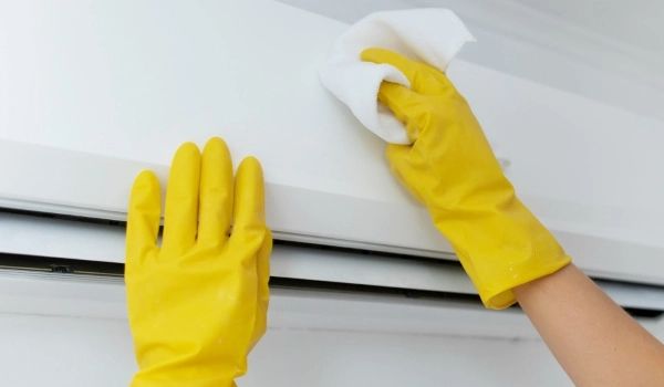 A person cleaning the AC