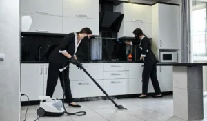 Cleaning service company employees removing cleaning kitchen with professional steam cleaner equipment