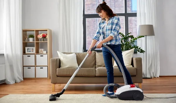 Asian woman with vacuum cleaner at home