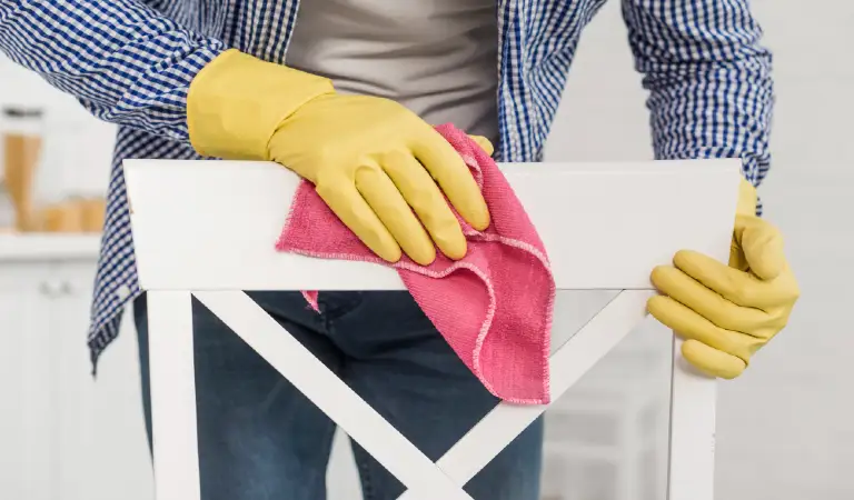 Front view of man cleaning a wooden chair