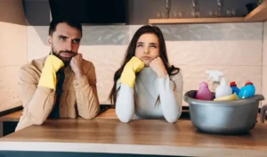 Wondering couple doing house cleaning in modern kitchen at home
