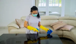 Young woman cleaning the table with disinfectant