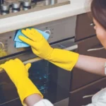 Young woman with rubber gloves cleaning the kitchen