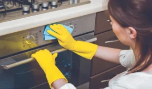 Young woman with rubber gloves cleaning the kitchen